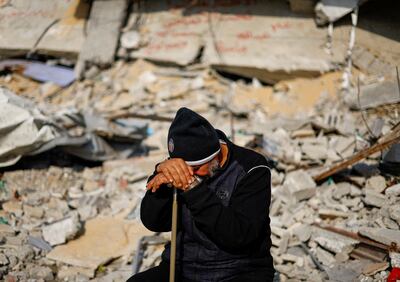 Ziad Mansour sits near the rubble of the Abu Aweidah family's house, which was destroyed in a deadly Israeli strike in Rafah, Gaza Strip, on January 9.  Reuters