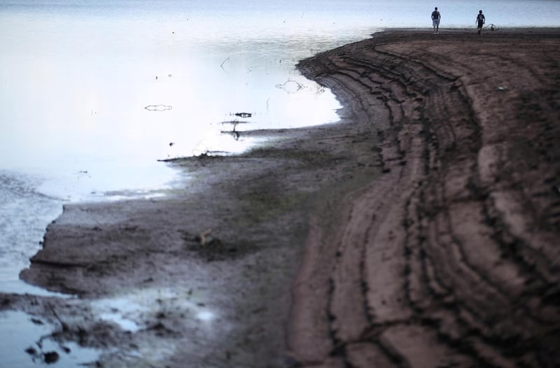 People are seen walking on the dried bed of Llwyn-on Reservoir as they enjoy the hot weather, following the outbreak of the coronavirus disease (COVID-19), Merthyr Tydfil, Wales, Britain. REUTERS