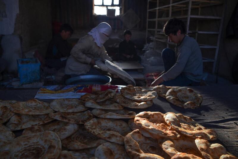 Hazara people make bread in a bakery at Dare-Folladi on the outskirts of Bamiyan Province on March 9, 2021. (Photo by WAKIL KOHSAR / AFP)