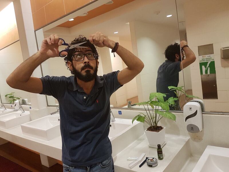 Syrian refugee Hassan Al Kontar tries to give himself a haircut in the bathroom at the Kuala Lumpur International Airport, where he was stranded for seven months, in Kuala Lumpur, Malaysia, August 21, 2018.  Photo taken August 21, 2018.  Courtesy of Hassan Al Kontar/Handout via REUTERS   ATTENTION EDITORS - THIS IMAGE WAS PROVIDED BY A THIRD PARTY.  NO RESALES, NO ARCHIVE