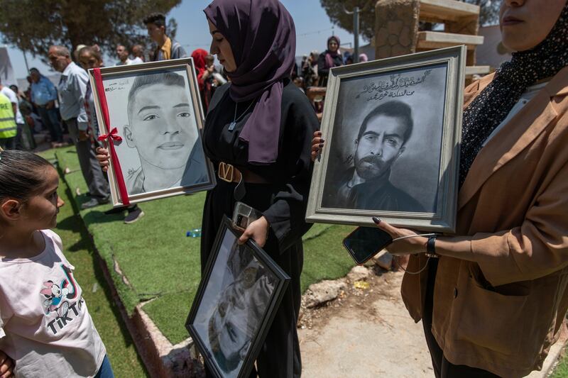 Artists with portraits of Palestinians killed during recent clashes between protesters and the Israeli army in the village of Beita.