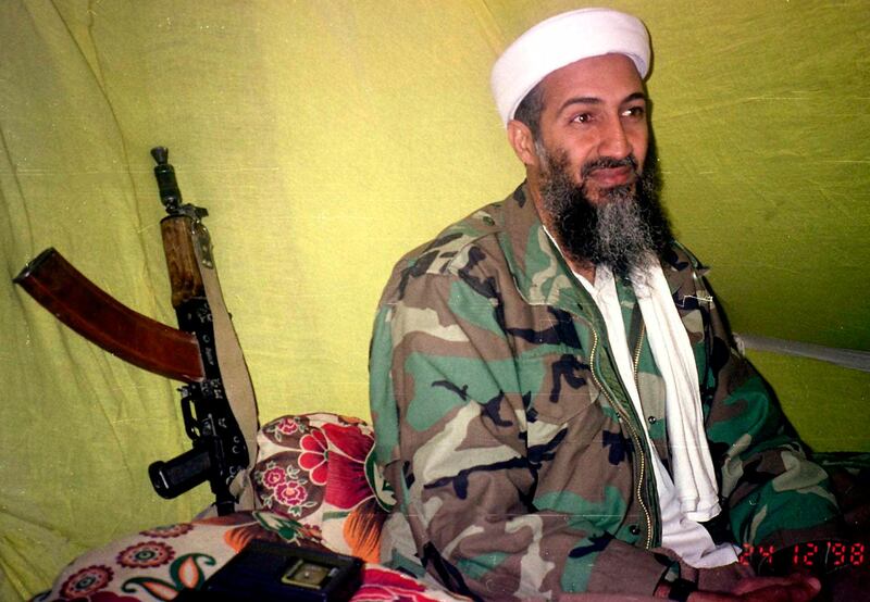 FILE - In this Dec. 24, 1998, file photo, al-Qaida leader Osama Bin Laden speaks to a selected group of reporters in mountains of Helmand province in southern Afghanistan. Years after the death of his father at the hands of a U.S. Navy SEAL raid in Pakistan, Hamza bin Laden himself clearly in the crosshairs of world powers. The U.S. has put up to a $1 million bounty for him. The U.N. Security Council has named him to a global sanctions list, sparking a new Interpol notice for his arrest. His home country of Saudi Arabia has revoked his citizenship. (AP Photo/Rahimullah Yousafzai, File)