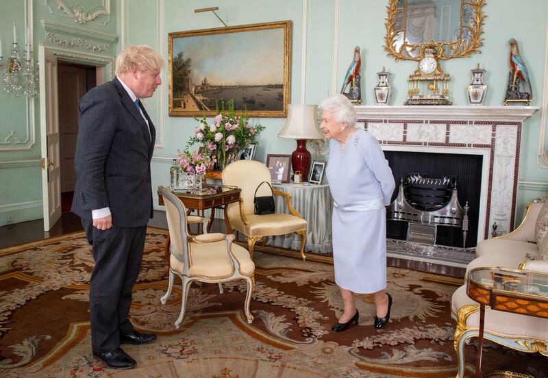Queen Elizabeth greets Prime Minister Boris Johnson during the first in-person weekly audience with the prime minister since the start of the coronavirus pandemic at Buckingham Palace in June.