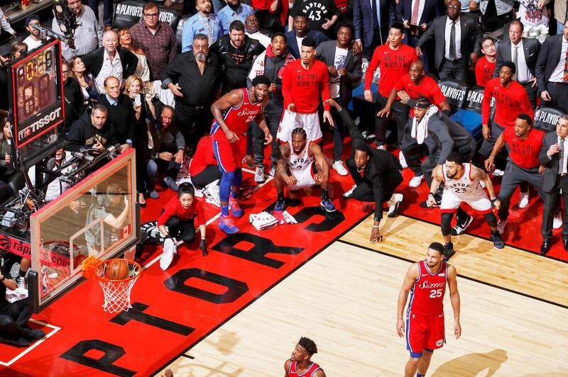 A photo by Mark Blinch shows Kawhi Leonard (squatting, center) of the Toronto Raptors watches his game-winning buzzer-beater shot go into the net, while playing against the Philadelphia 76ers in Game 7 of the Eastern Conference Semifinals of the 2019 National Basketball Association Playoffs, at the Scotiabank Arena, Toronto, Canada, on May 12, 2019, wins first prize in Sports Single category. Mark Blinch / EPA