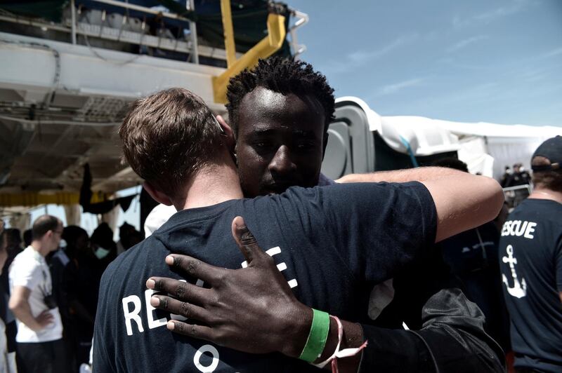 A migrant hugs a crew member before disembarking from the Aquarius rescue ship after arriving to port in Valencia, Spain, June 17, 2018. Kenny Karpov/SOS Mediterranee/Handout via Reuters ATTENTION EDITORS - THIS PICTURE WAS PROVIDED BY A THIRD PARTY.
