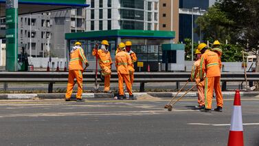 Workers clear a road following floods caused by heavy rains in Dubai, on April 19. Bloomberg