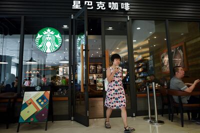 A customer walks out of a Starbucks coffee shop in Beijing on August 2, 2018. 
Starbucks on August 2 announced a partnership with e-commerce giant Alibaba that will give the US coffee giant greater access to China's growing food-delivery market as it faces increased competition from local firms. / AFP PHOTO / WANG ZHAO