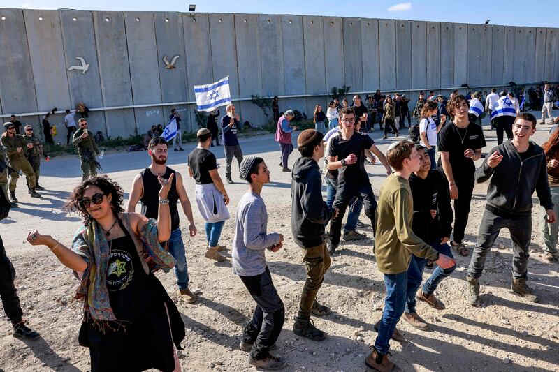 People dance as Israeli protesters gather to block the entry of humanitarian aid trucks to the Gaza Strip at the Kerem Shalom border crossing. AFP