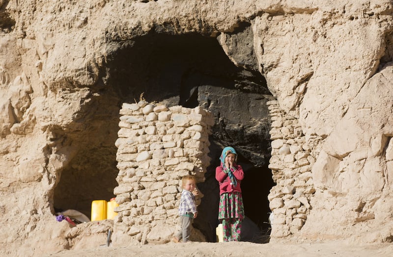 Shepha Qah, 8, and her brother stand by the entrance of their cave in Bamiyan, Afghanistan. Their family and about 240 others living in caves are to be moved away as part of a government plan to turn the area into a tourist site. Massoud Hossaini / AP Photo