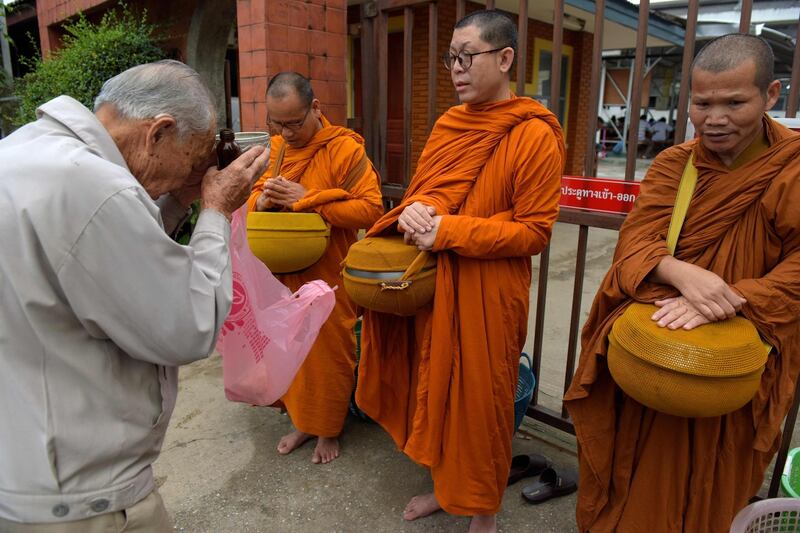 A Thai man prays to Buddhist monks. AFP