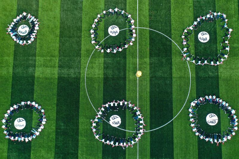 This picture taken on November 19, 2022 shows an aerial view of youths performing during the opening ceremony of the "Camps World Cup" at the newly-reopened Idlib Municipal Stadium in the rebel-held northwestern Syrian city.  - More than 300 children in rebel-held northwest Syria kicked off their own football World Cup on November 19, with organisers hoping to shine a light on communities battered by 11 years of war.  The excited children took part in the opening ceremony at the municipal stadium in Idlib, wearing the jerseys of this year's World Cup teams.  Their 32 squads correspond to the nations that have qualified for the World Cup, which starts the following day in Qatar, and their competition opened with a match between the host country and Ecuador, reflecting the official schedule.  (Photo by Omar HAJ KADOUR  /  AFP)