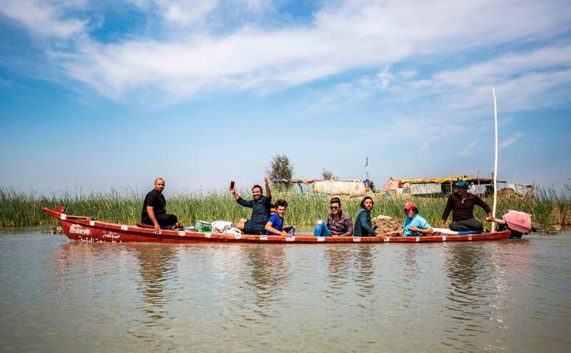 Tourists sit in a canoe as they are shown around the marshes of the southern Iraqi district of Chibayish in Dhi Qar province. AFP