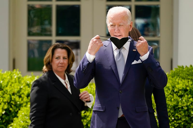 Mr Biden takes off his mask to speak. AP