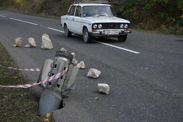 A car drives past the remains of a rocket shell on a road near the disputed Nagorno-Karabakh province's town of Shusha. AFP