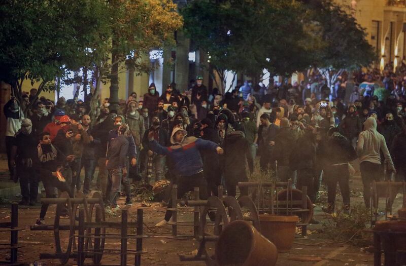 Protesters throw stones at riot police during clashes in central Beirut. EPA