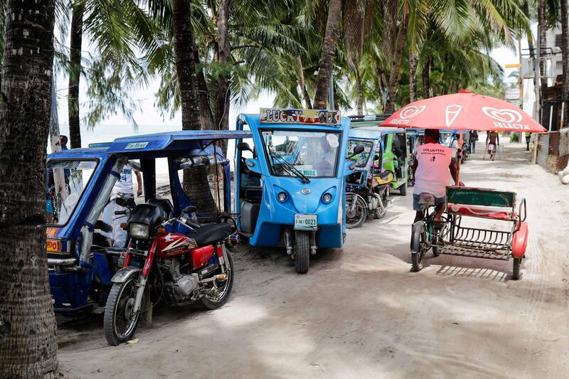 Tricycles and e-trikes wait for daytrippers.