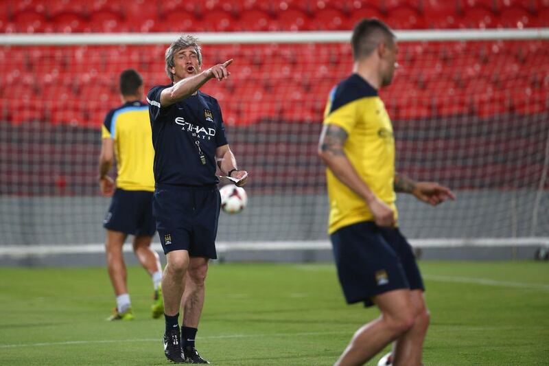 Manchester City manager Manuel Pellegrini shouts an instruction during his side's training session at the Mohammed bin Zayed Stadium in Abu Dhabi on Wednesday. Marwan Naamani / AFP / May 14, 2014