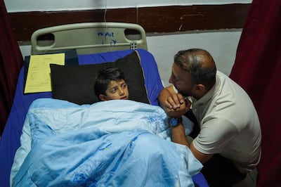 A relative checks on Sipan Farhad, 9,  who was wounded in a rocket attack in the Kurdish autonomous region of Iraq. AFP