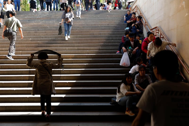 Chinese tourists rest at the underpass of the Tiananmen Square in Beijing.  EPA