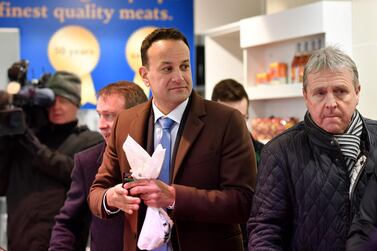 Ireland's Prime Minister and leader of the Fine Gael party party, Leo Varadkar (C) holds his purchase of meat as he leaves a butcher's shop, whilst canvassing for support in Ennis, County Clare. AFP