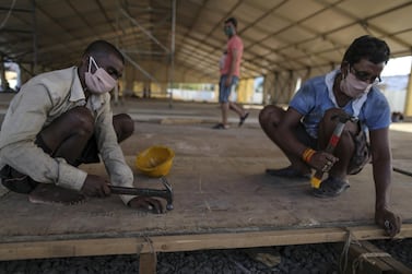 Workers lay flooring panels during the construction of a 1,000 bed hospital for non-critical Covid-19 patients at the Bandra Kurla Complex exhibition ground in Mumbai, India on May 6, 2020. Bloomberg