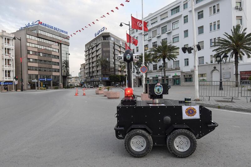 A Tunisian police robot patrols along Avenue Habib Bourguiba in the centre of the capital Tunis on April 1, 2020, as a means of enforcing a nationwide lockdown to combat the COVID-19 coronavirus pandemic. The locally-built robots are remotely operated and equipped with infrared and thermal imaging cameras, in addition to a sound and light alarm system. / AFP / FETHI BELAID
