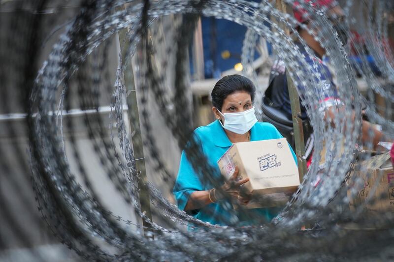 A resident outside the Pangsapuri Permai housing estate, which is under an enhanced movement control order because of a severe  increase in the number of Covid-19 cases recorded over the past 10 days in Cheras, outside Kuala Lumpur, Malaysia. AP Photo