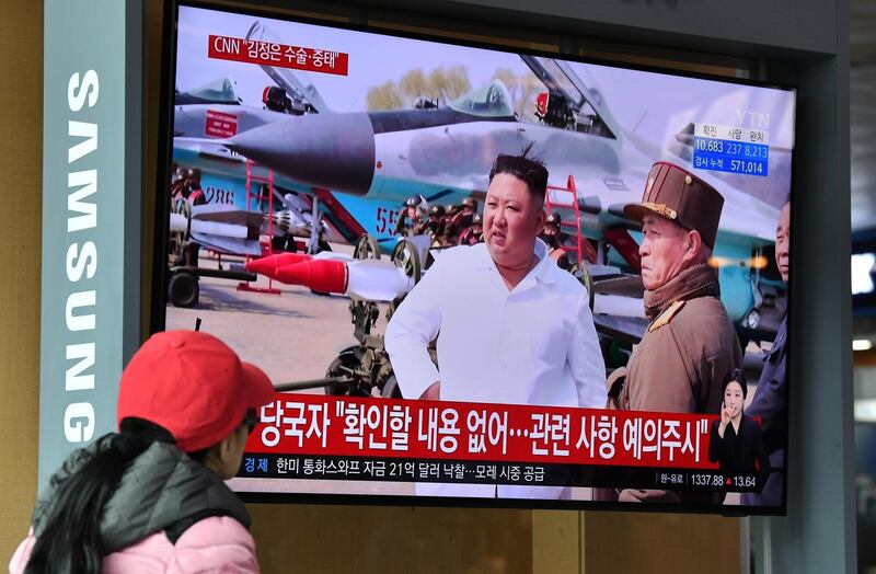 A woman watches a television news broadcast showing file footage of North Korean leader Kim Jong Un, at a railway station in Seoul on April 21, 2020.  AFP