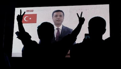 FILE PHOTO: Supporters of Turkey's main pro-Kurdish Peoples' Democratic Party (HDP) watch the jailed former leader and presidential candidate Selahattin Demirtas as his first television appearance in over a year and a half is seen live on a huge screen during campaign event in Istanbul, Turkey, June 17, 2018. REUTERS/Huseyin Aldemir/File Photo