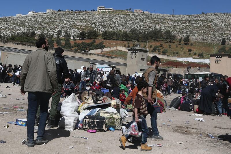 Syrian civilians and rebel fighters evacuated from Eastern Ghouta arrive in the village of Qalaat al-Madiq, some 45 kilometres northwest of the central city of Hama, on March 26, 2018, as evacuations from Eastern Ghouta continued following a deal that was announced earlier in the week. Abdulmonam Eassa / AFP