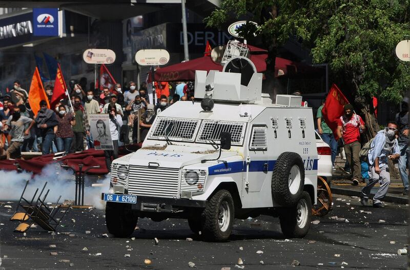 A Turkish protester, right,  throws a stone at police vehicle as the protesters clash with security forces in Ankara, Turkey, Saturday, June 1, 2013. Turkish police retreated from a main Istanbul square Saturday, removing barricades and allowing in thousands of protesters in a move to calm tensions after furious anti-government protests turned the city center into a battlefield. A second day of national protests over a  violent police raid of an anti-development sit-in in Taksim square has revealed the depths of anger against Prime Minister Recep Tayyip Erdogan, who many Turks view as increasingly authoritarian and dismissive of opposing views.(AP Photo/Burhan Ozbilici)