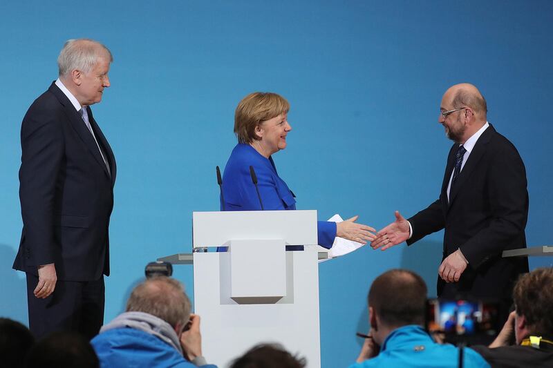 Angela Merkel, Germany's chancellor, center, shakes hands with Martin Schulz, leader of the Social Democrat Party (SPD), right, as Horst Seehofer, leader of the Christian Social Union (CSU) party, looks on at the end of a news conference following overnight coalition negotiations, at the SPD headquarters in Berlin, Germany, on Friday, Jan. 12, 2018. After a marathon of more than 24 hours of talks to end Germany’s political gridlock, leaders of Merkel’s Christian Democratic Union, her Bavarian sister party and the Social Democrats hammered out a 28-page agreement. Photographer: Krisztian Bocsi/Bloomberg