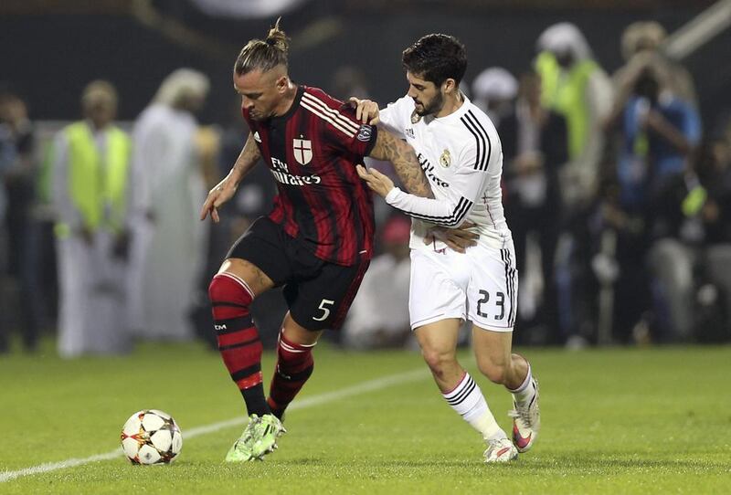 Real Madrid's Isco (R) fights for the ball with AC Milan's Philippe Mexes during their friendly soccer match in Dubai December 30, 2014. REUTERS/Stringer (UNITED ARAB EMIRATES - Tags: SPORT SOCCER)