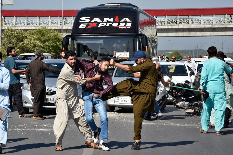 Plain-clothes police officers beat a Khan supporter during a protest in Peshawar. AP