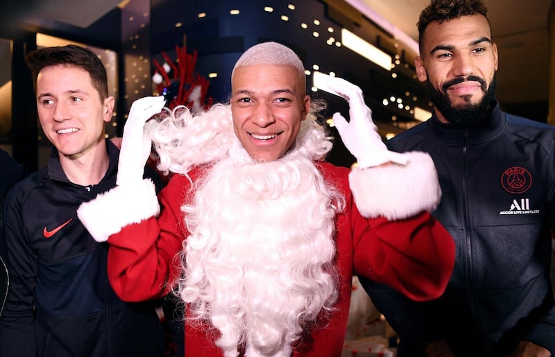 MBappe dressed as Santa Clauswith Ander Herrera and Eric Maxim Choupo-Moting. AFP