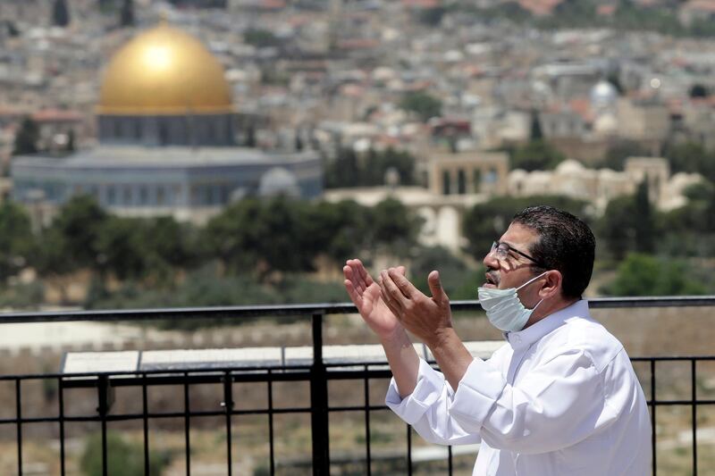 A man prays in east Jerusalem's Mount of Olives, overlooking the Dome of the Rock and Al Aqsa mosque compound, which remains shut to prevent the spread of coronavirus during Ramadan. AP Photo