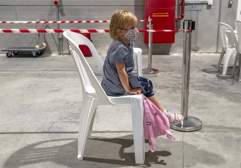 Abu Dhabi, United Arab Emirates, March 18, 2021.  A little girl waits patiently on her chair before she gets saliva tested at the Biogenix lab at G42 in Masdar City.
Victor Besa/The National
Section:  NA
Reporter:  Shireena Al Nowais