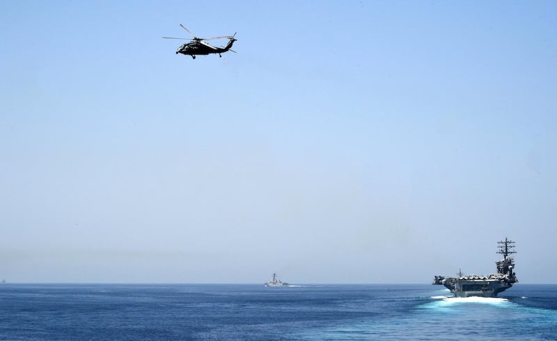 In this image released by the US Navy, the aircraft carrier USS Nimitz (R) transits the Strait of Hormuz on September 18, 2020. - The Nimitz group passed the Strait of Hormuz to enter the Gulf on September 18, amid Washington threats to enforce "UN" sanctions without the backing of Security Council partners, the US Navy announced. The strike group led by the Nimitz and including two guided-missile cruisers and a guided-missile destroyer sailed into the Gulf to operate and train with US partners and support the coalition fighting the Islamic State group, the US 5th Fleet said in a statement. (Photo by Logan C. Kellums / US NAVY / AFP) / RESTRICTED TO EDITORIAL USE - MANDATORY CREDIT "AFP PHOTO / US Navy / Mass Communication Specialist 2nd Class Logan C. Kellums" - NO MARKETING - NO ADVERTISING CAMPAIGNS - DISTRIBUTED AS A SERVICE TO CLIENTS