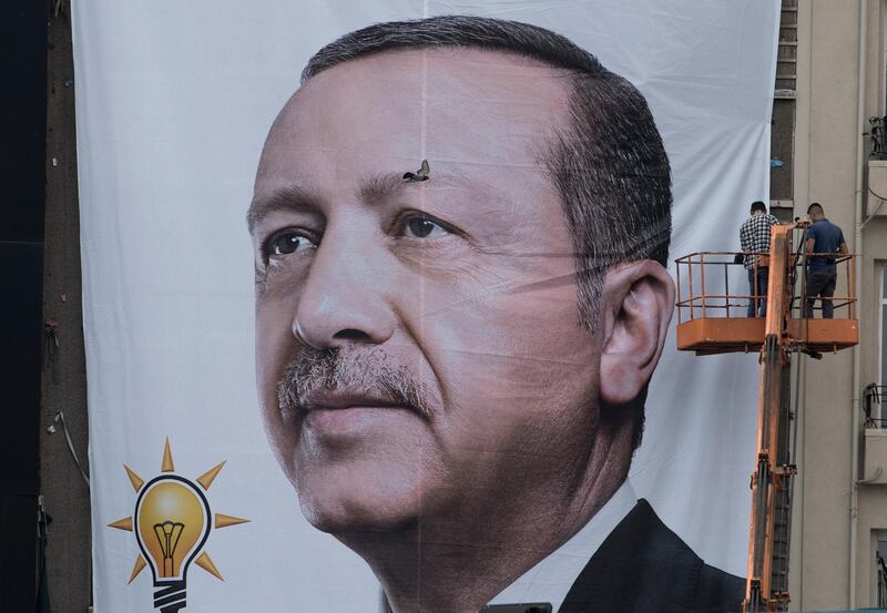 epaselect epa06841770 Workers hang up a wall poster of Turkish President Recep Tayyip Erdogan at Taksim Square in Istanbul, Turkey, 26 June 2018.  Turkish Electoral Commission on 26 June announced Recep Tayyip Erdogan has won the presidential elections. In the parliamentary elections, which were held at the same time as the presidential elections, although the Justice and Development Party (AKP) won with 42.5 percent of the votes, it lost the absolute majority which the party had secured in the parliament since 2002.  EPA/SEDAT SUNA