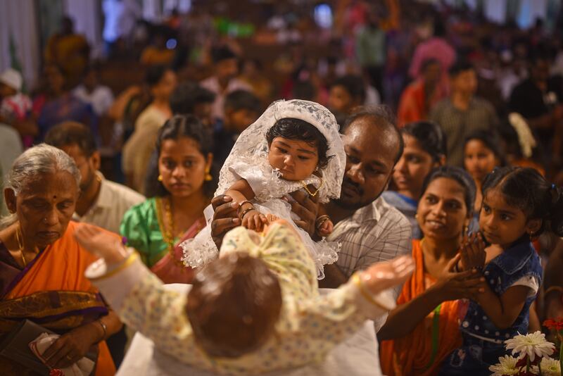 A child touches the feet of a statue depicting the infant Jesus Christ during Christmas Holy Mass, at Santhome Cathedral Basilica, India. EPA