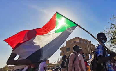 A protester carries Sudan's national flag during demonstrations against the October 2021 military coup, in the capital Khartoum, on January 9.  Photo: AFP 