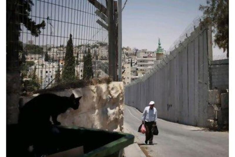 A Palestinian man walks next to Israel's separation barrier in the West Bank village of Abu Dis on the outskirts of Jerusalem in July last year.