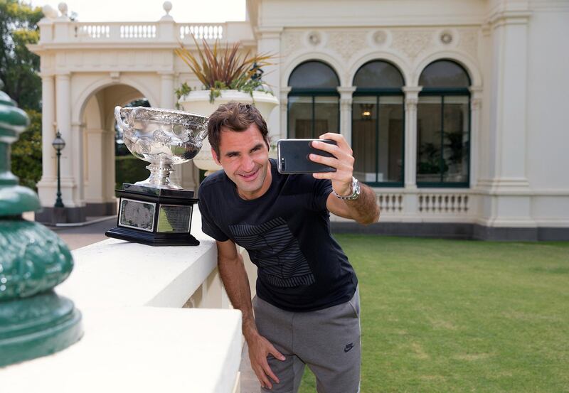 A supplied photo shows Switzerland's Roger Federer taking a selfie with the Australian Open Men's singles trophy during a visit to Government House in Melbourne, Australia, January 29, 2018.        Fiona Hamilton/Tennis Australia/Handout via REUTERS  ATTENTION EDITORS - THIS IMAGE WAS PROVIDED BY A THIRD PARTY. NO RESALES. NO ARCHIVE.