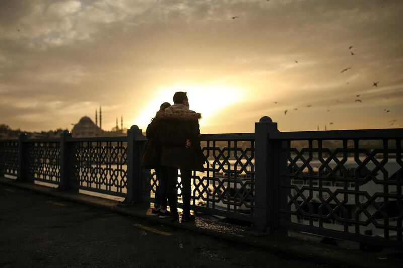 People watch the sunset from a bridge in Istanbul's Golden Horn. AP Photo