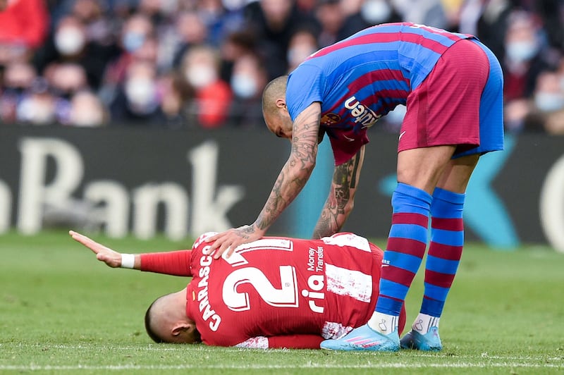 Atletico Madrid midfielder Yannick Ferreira-Carrasco lies on the ground after a foul by Barcelona's Dani Alves. AFP