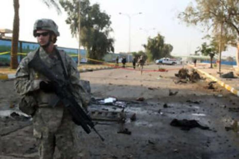 An American soldier guards the site of twin blasts in central Baghdad that killed six people on Monday.