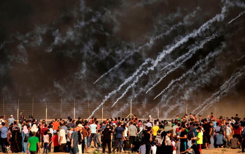 Tear gas canisters fired by Israeli forces landing amid protesters during a demonstration along the border with Israel east of Gaza City on July 13. AFP