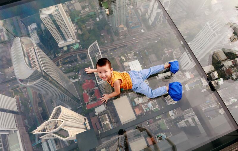 A boy plays on the glass at Thailand's first skywalk in Bangkok, Thailand. Reuters