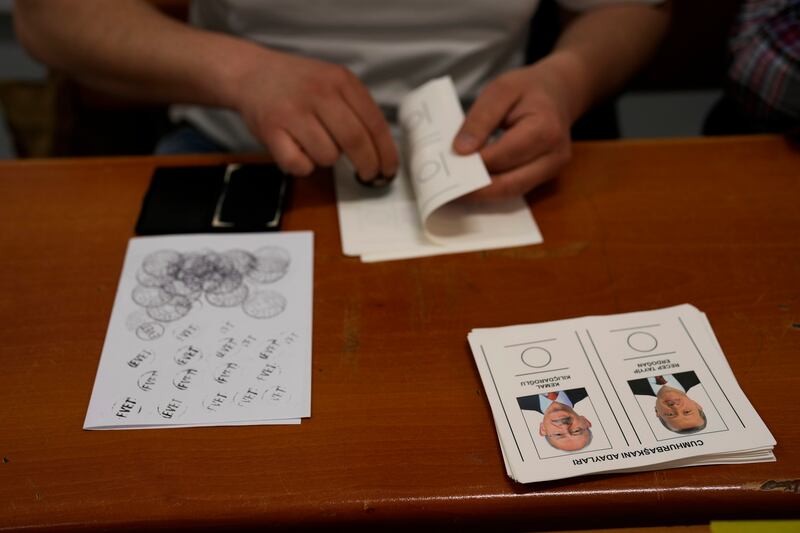 An election representative checks a stamp at a polling station in Istanbul. AP