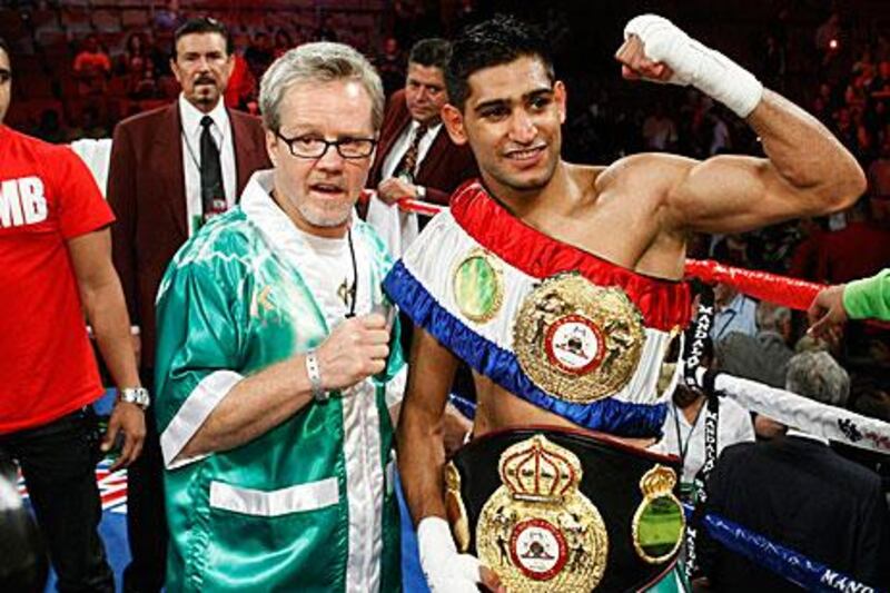 Amir Khan, right, celebrates his light-welterweight unification bout victory against Zab Judah with his trainer Freddie Roach.